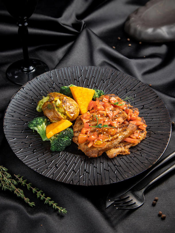 Свиная отбивная с томатами конкассе, свежими овощами и запечённым картофелем Свиная отбивная с томатами конкассе, свежими овощами и запечённым картофелем